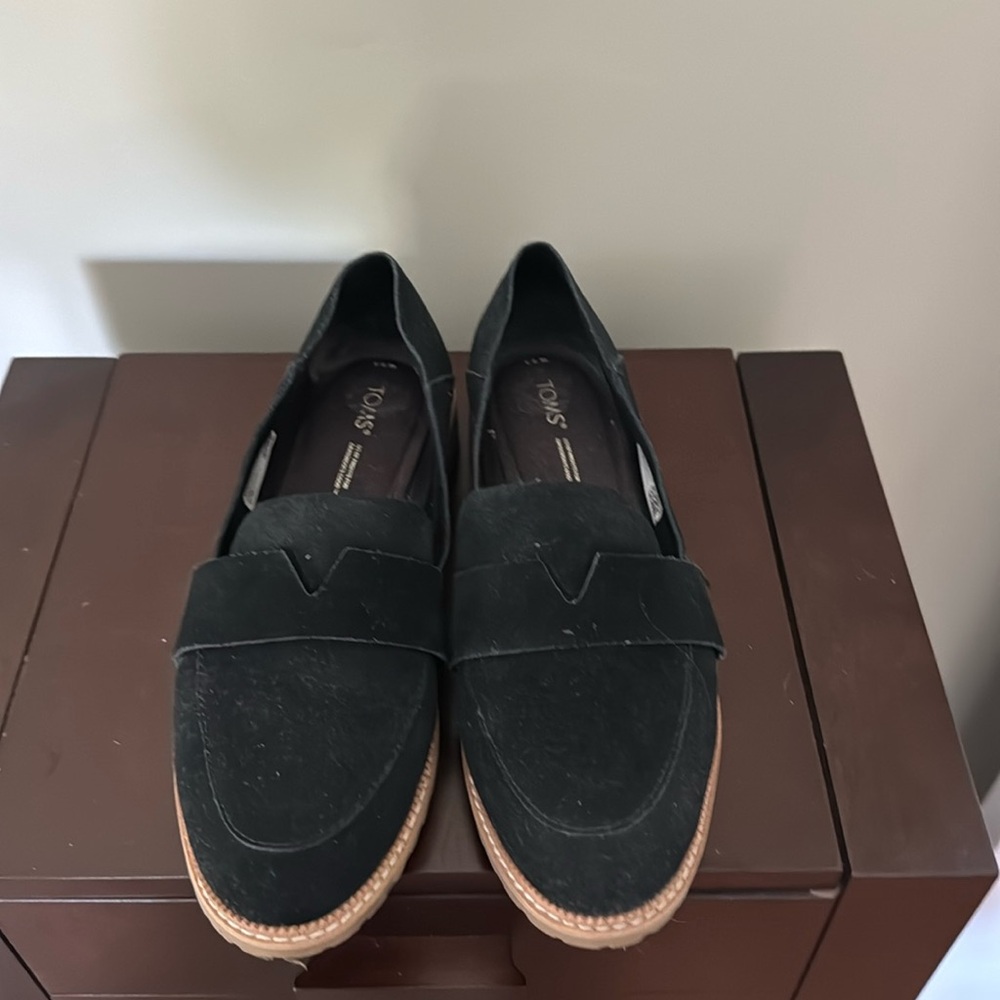 Tom’s black loafers